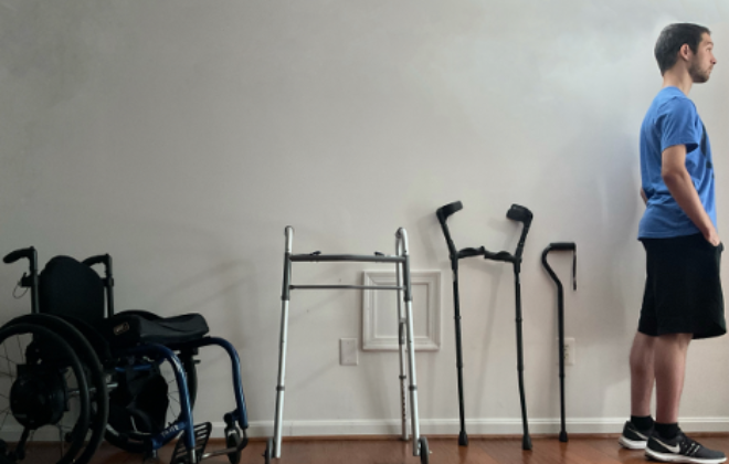 Former Shepherd Center patients stands in front of mobility aids from a wheelchair to a cane symbolizing the progression and pathway to recovery